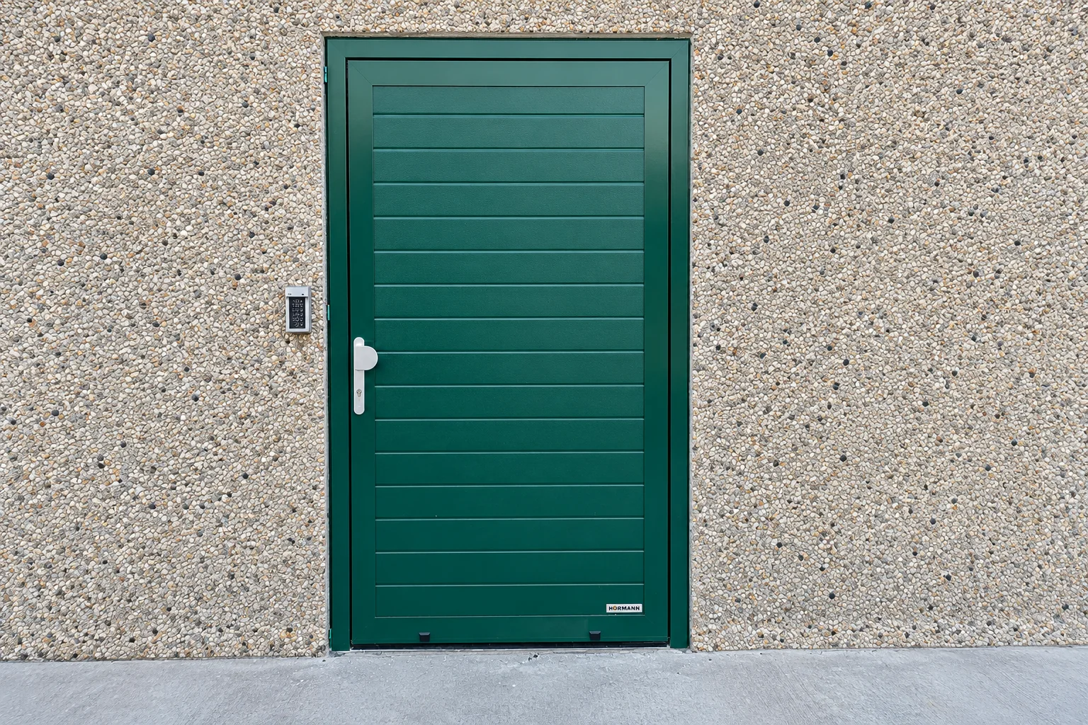Groen aluminium loopdeur met horizontale latten en witte deurkruk tegen grijze steensteen muur.