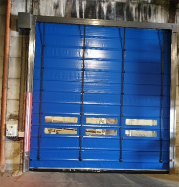 Blauwe snelrolpoort met gele hendels en donkere horizontale banden in een bakstenen deuropening.