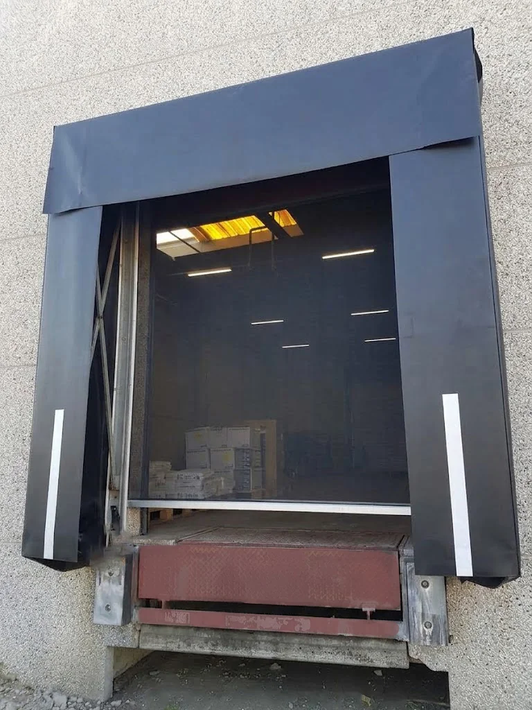 Gesloten vliegengaaspoort met donkergrijs aluminium frame en zwarte gaasschermen aan de zijkanten van de opening.